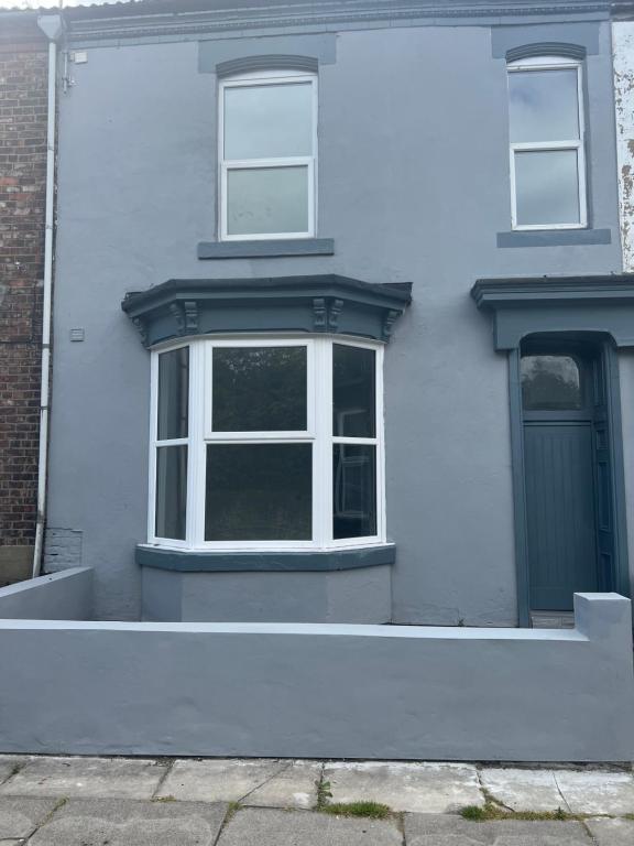 a white house with two windows and a door at Liley Apartments in Stockton-on-Tees