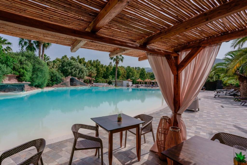a patio with a table and chairs next to a pool at Il Monastero in Geremèas