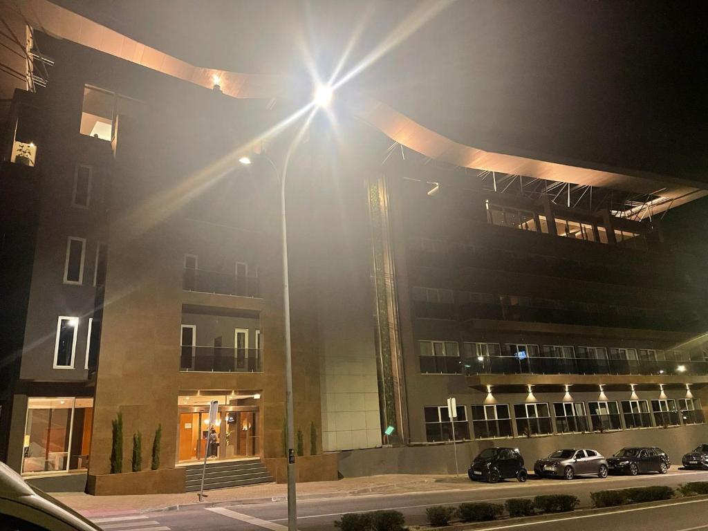 a street light in front of a building at night at Hotel Versatile in Guarda