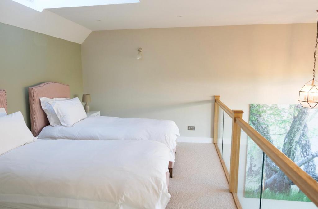 two beds in a room with a balcony at The Silver Birch Cottage - Greentrees Estate in Haywards Heath