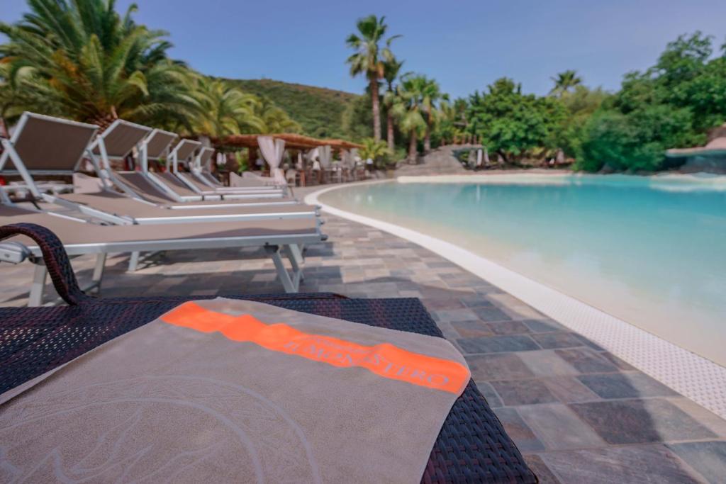 a swimming pool with a bunch of chairs next to it at Il Monastero in Geremèas