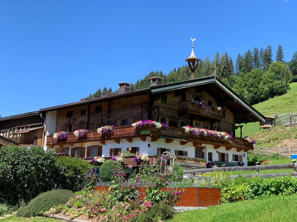 un edificio en una colina con flores. en Reitstall Henntalhof en Kitzbühel