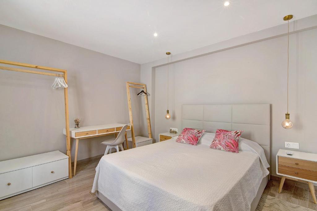 1 dormitorio con 1 cama blanca y 2 almohadas rojas en Casa Rebelo da Silva, en Faro
