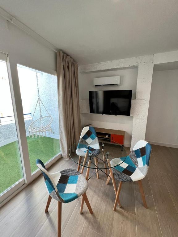 ein Wohnzimmer mit 2 Stühlen und einem TV in der Unterkunft Apartamentos Buganvilla Roquetas de Mar in Roquetas de Mar