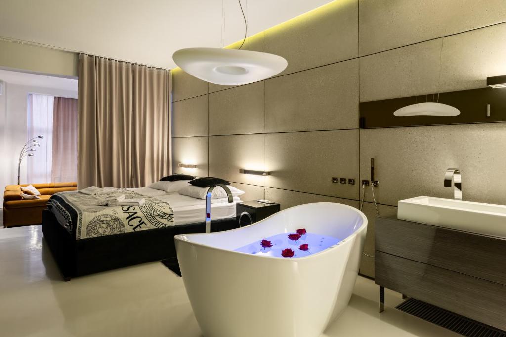 ビェルスコ・ビャワにあるApartament z jacuzzi City Life Centrumのバスルーム(バスタブ付)、ベッド1台が備わります。