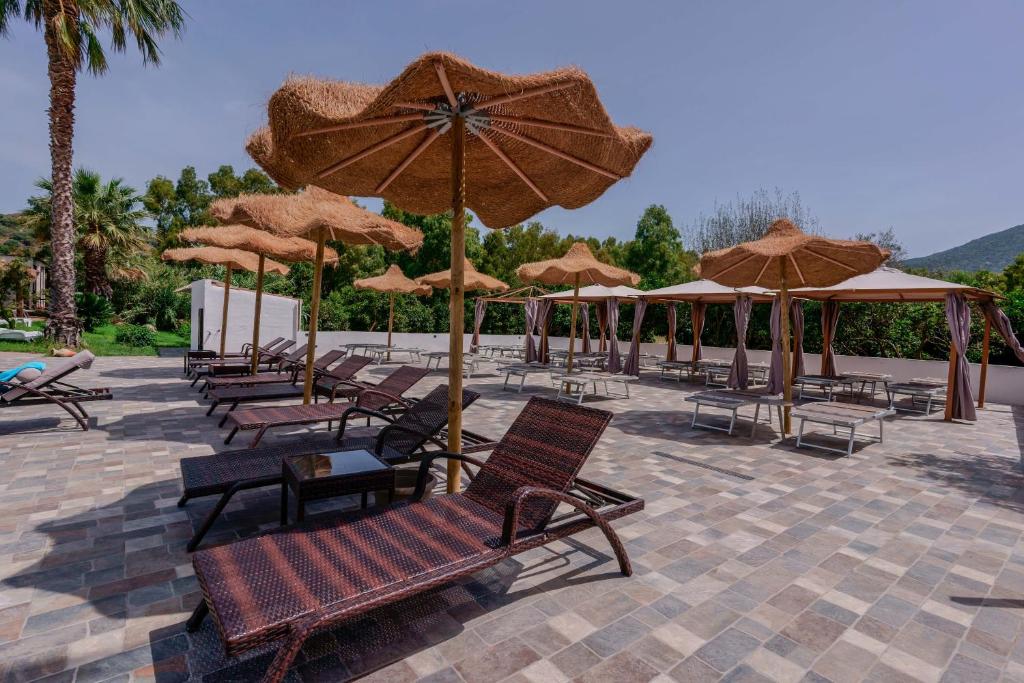 a group of chairs and umbrellas on a patio at Il Monastero in Geremèas