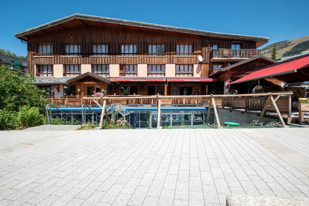 a large building with a pool in front of it at Hotel le Sherpa in Les Deux Alpes