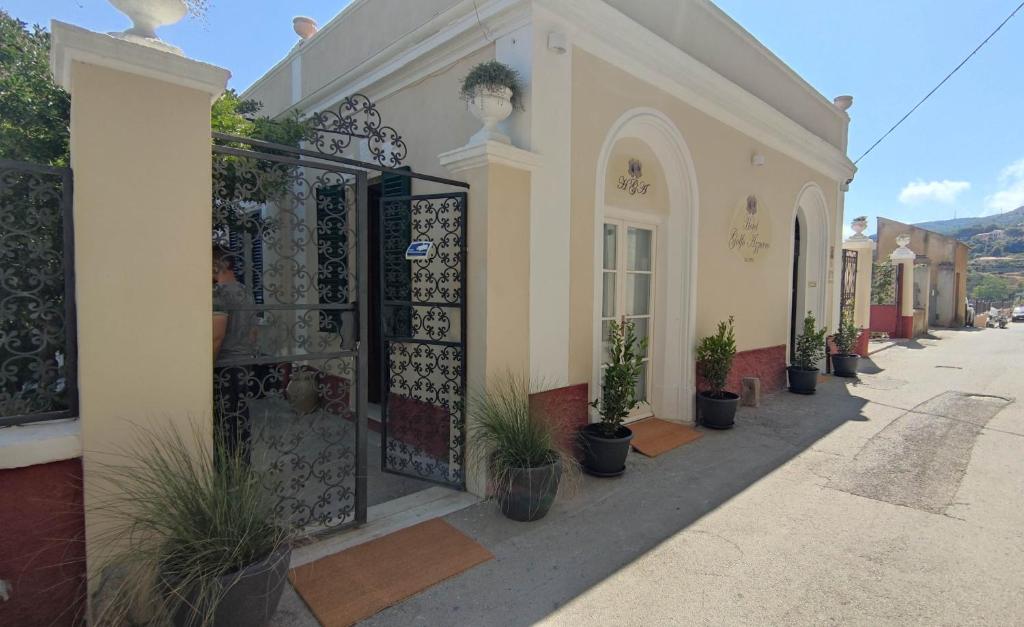 a building with potted plants sitting outside of it at Hotel Golfo Azzurro in Capoliveri