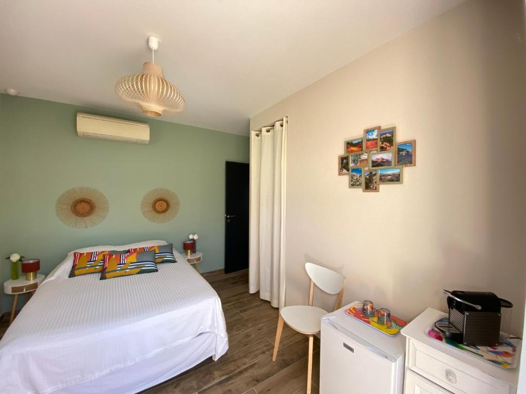 a bedroom with a bed and a table and chairs at L’oliveraie in Robion en Luberon