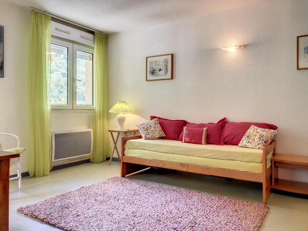 sala de estar con sofá y alfombra rosa en Appartement 20, avec balcon, Résidence de l'Ars en Aulus-les-Bains