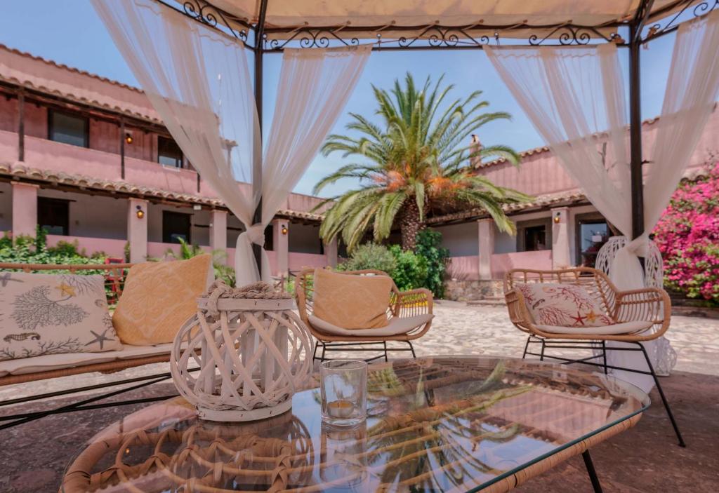 a group of chairs and a glass table on a patio at Il Monastero in Geremèas