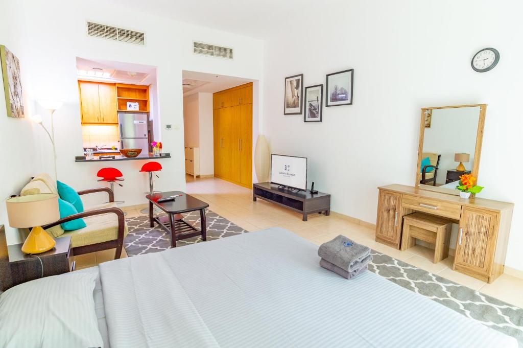 a bedroom with a bed and a living room at Fully equipped studio near to metro - HRI in Dubai