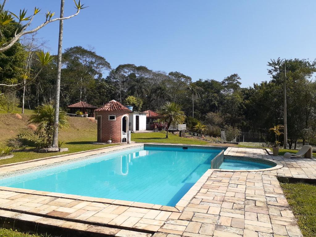 una piscina en un patio junto a una casa en Sítio Zen 37 hectares de flora e fauna preservadas, a 50" da Capital, com wifi 30mbps! en Mogi das Cruzes