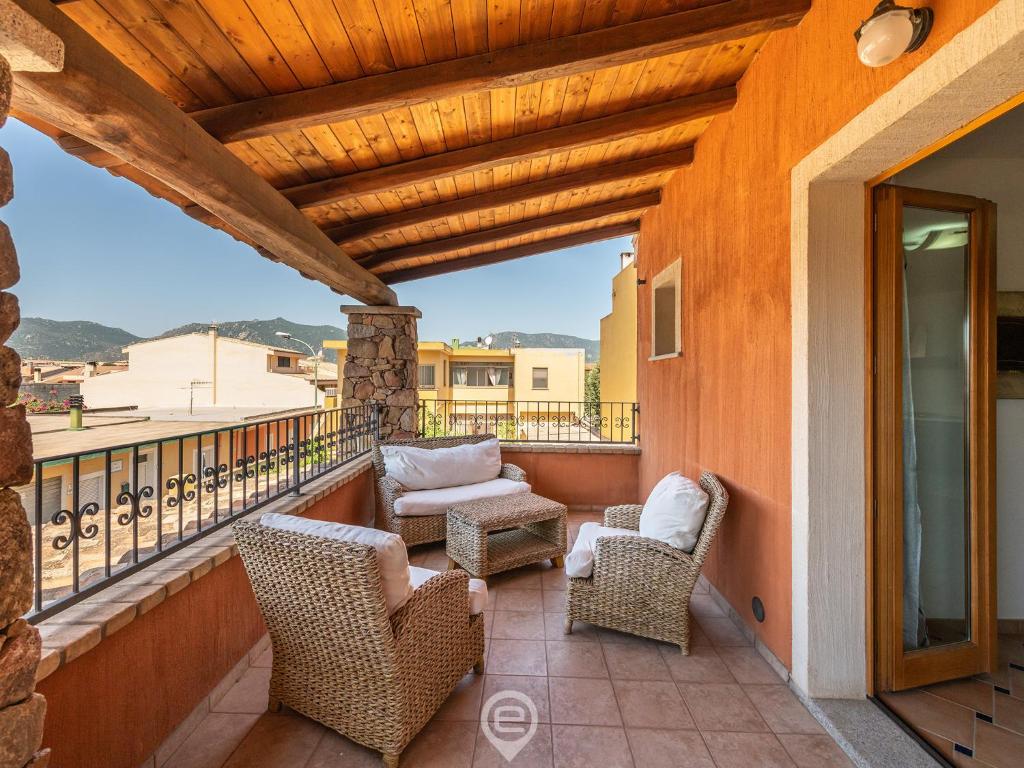 a balcony with wicker chairs and a wooden ceiling at House Federica in Villasimius