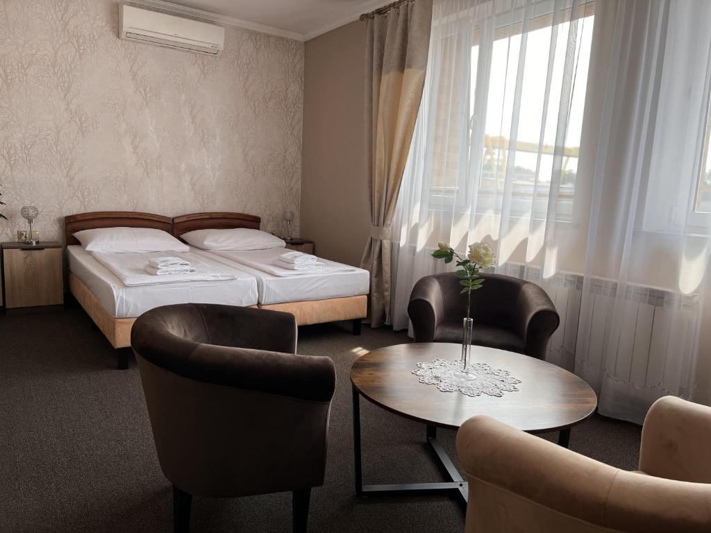 a hotel room with two beds and a table and chairs at Noclegi-Restauracja Boss in Mogilno