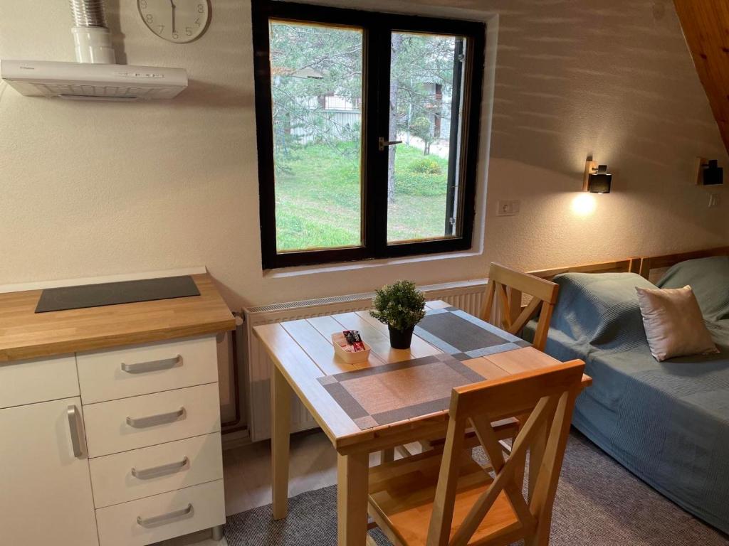 a kitchen and dining room with a table and a window at Smeštaj Nedić Karaula in Zlatibor