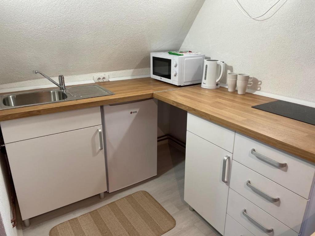 a kitchen with a sink and a microwave on a counter at Smeštaj Nedić Karaula in Zlatibor