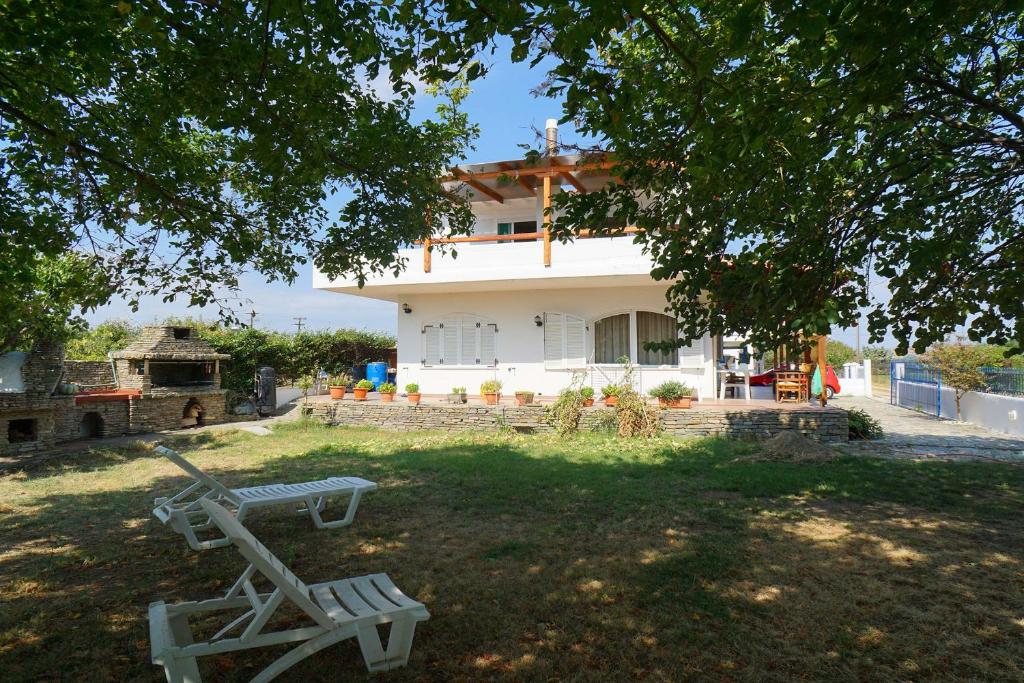 Uma casa branca com uma mesa de piquenique à frente. em Seaside House em Ávdhira