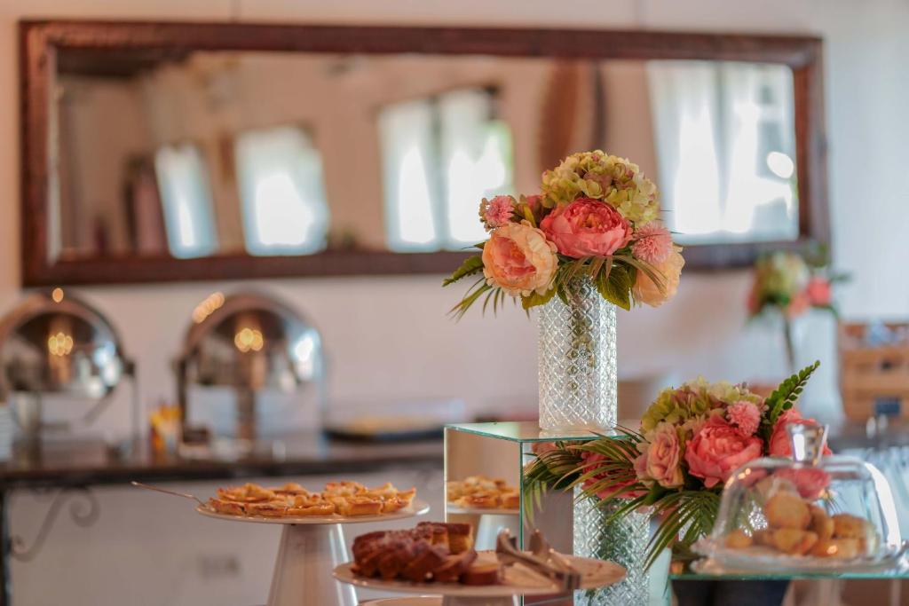 a table with a vase filled with flowers and food at Il Monastero in Geremèas