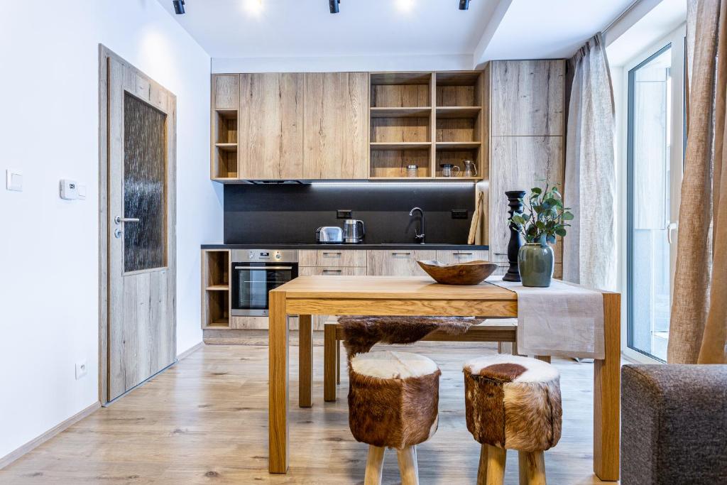 a kitchen with a wooden table and chairs at Klínovec-Apartments in Loučná pod Klínovcem