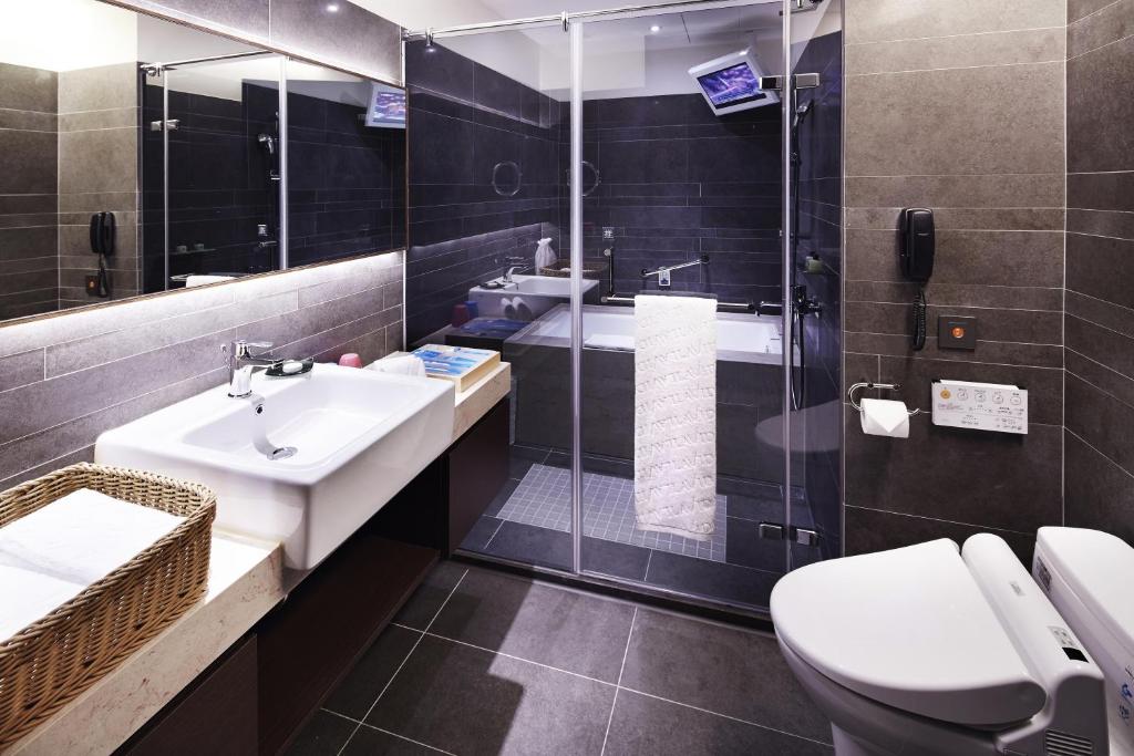 a bathroom with a toilet and a sink and a shower at La Vida Hotel in Taichung
