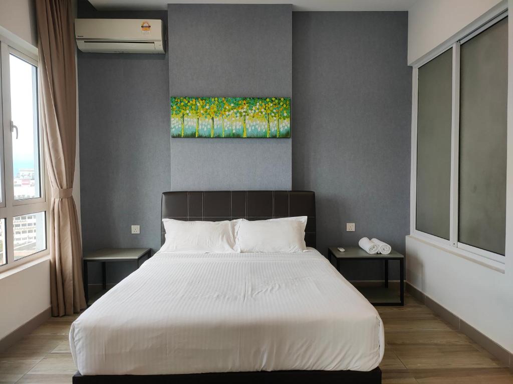 怡保的住宿－八角形怡保公寓，卧室配有一张床,墙上挂有绘画作品