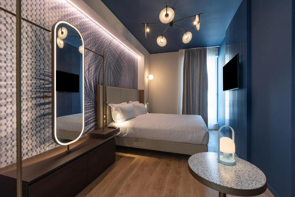 a bedroom with a bed and a mirror and a table at Boutique Hotel Martini 17 in Milan