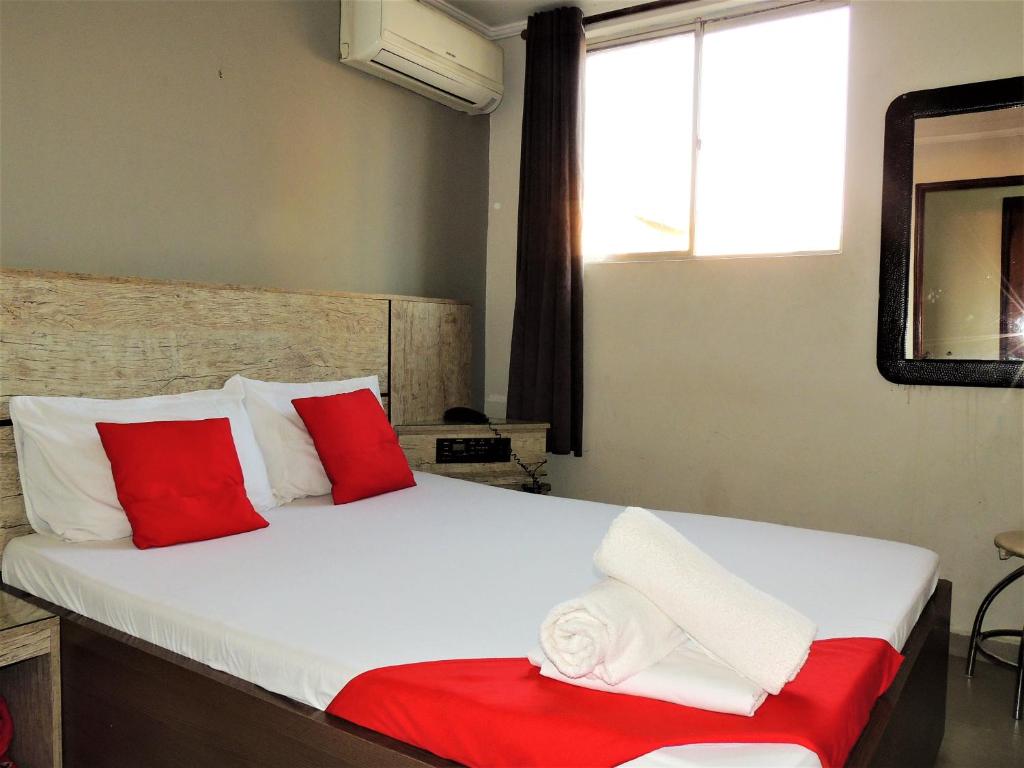Schlafzimmer mit einem Bett mit roten und weißen Kissen in der Unterkunft Hotel Vila Prudente São Paulo - By Up Hotel - fácil acesso Expo São Paulo e Museu Ipiranga in São Paulo