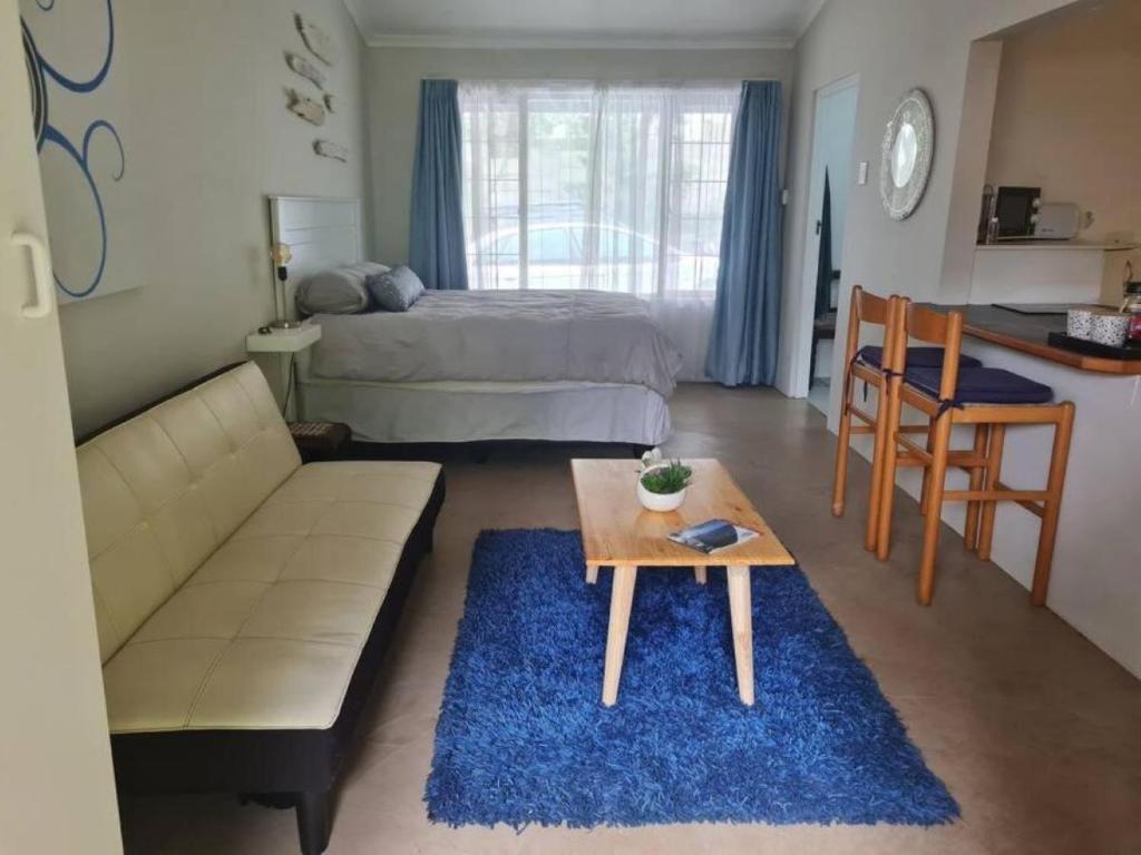 uma sala de estar com um sofá e uma mesa em Lovely 1 Queen bed, 1 Sleeper couch Self-catering cottage em Kloof