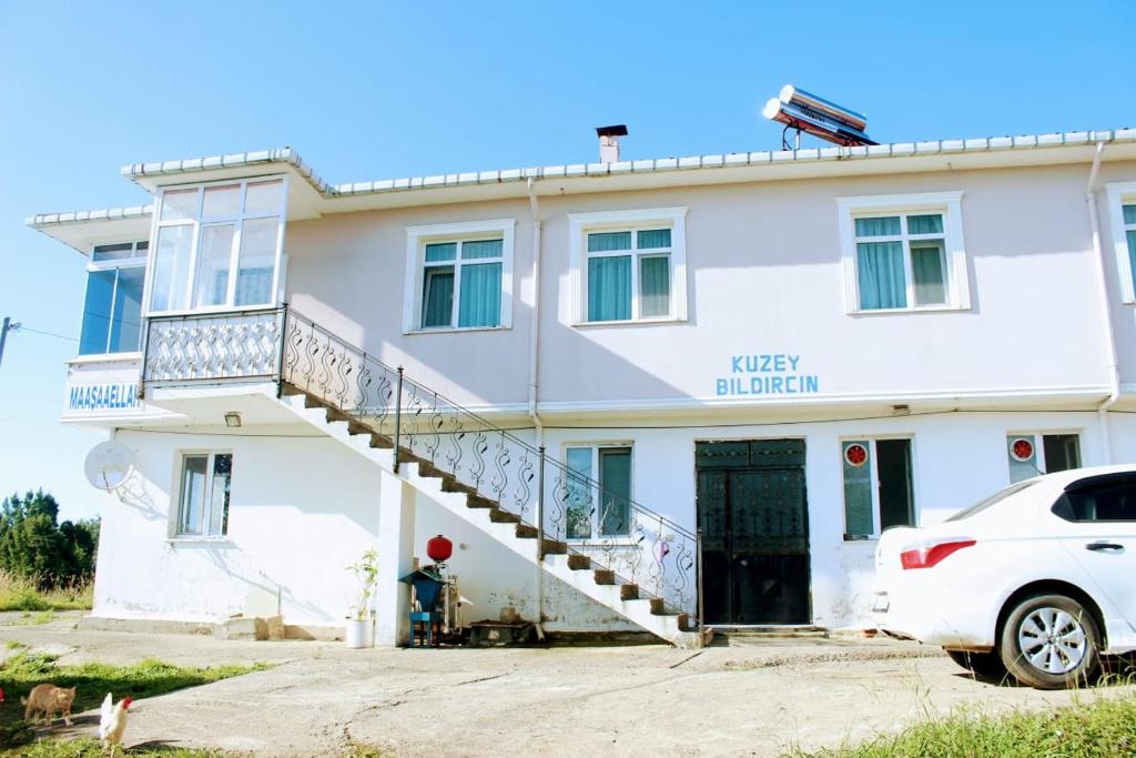 PazarにあるKUZEY APART OTELの白車が正面に停まった白い家