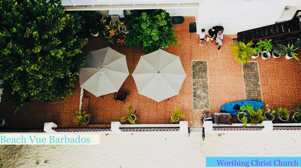 two white umbrellas on the side of a building at Beach Vue Barbados in Bridgetown