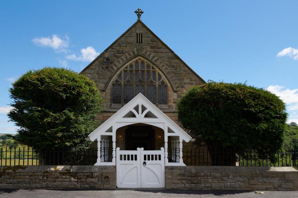 una iglesia con una puerta blanca y una puerta en Devonshire Arms Holiday Cottages at Bolton Abbey en Bolton Abbey