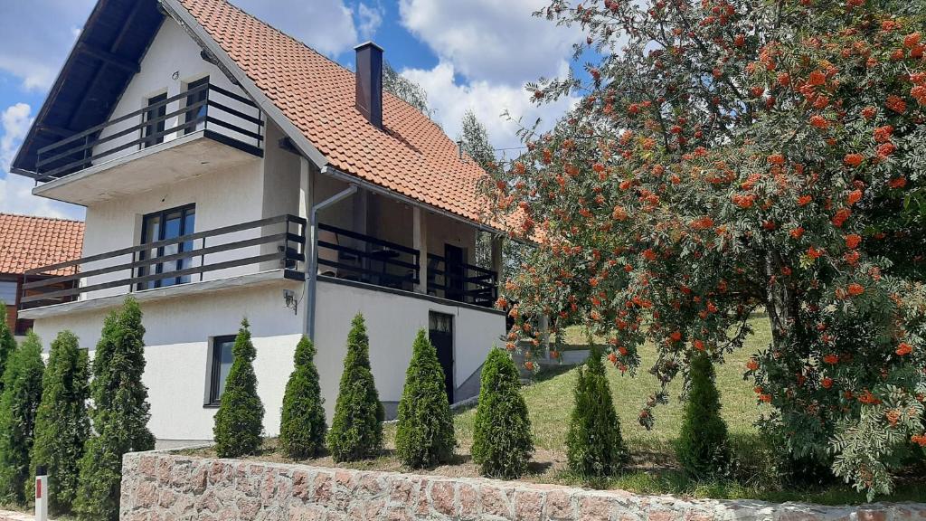 una casa bianca con un albero davanti di Kuća sa pogledom na Tornik a Zlatibor
