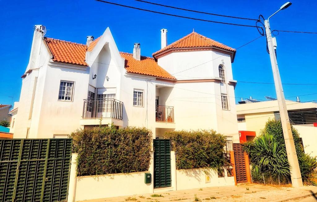 een groot wit huis met een oranje dak bij Villa Cielo - Family House in Sintra