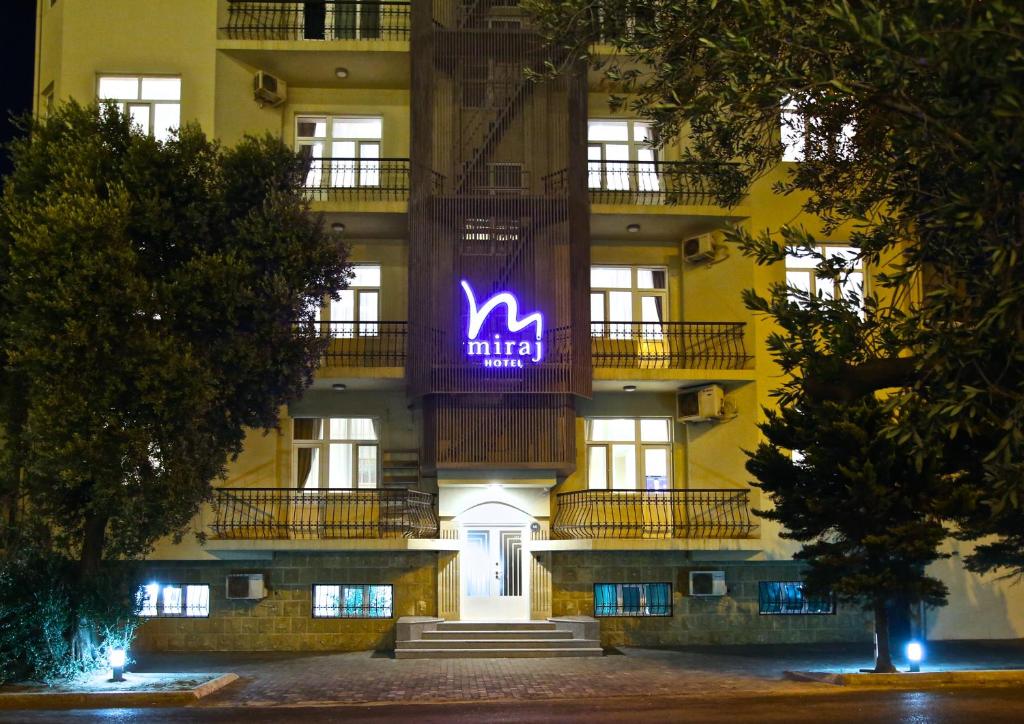 um edifício com um sinal roxo na lateral em Miraj hotel em Baku