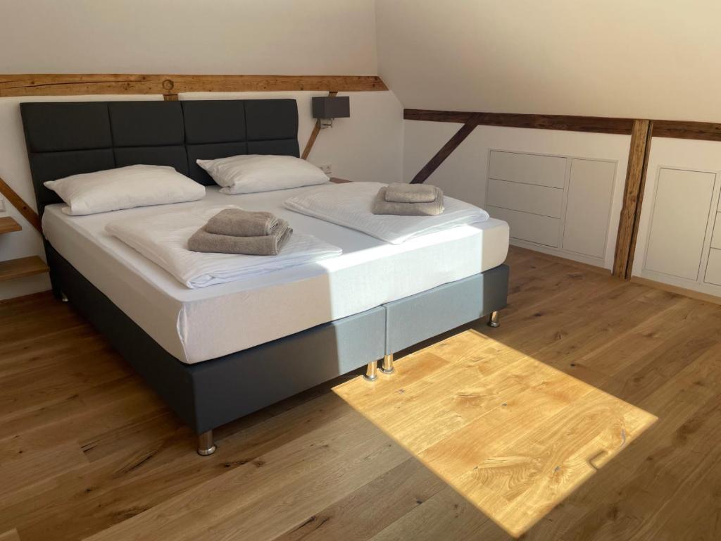 un grande letto in una camera con pavimenti in legno di Remise Kubus in der Villa Kubus a Langenargen