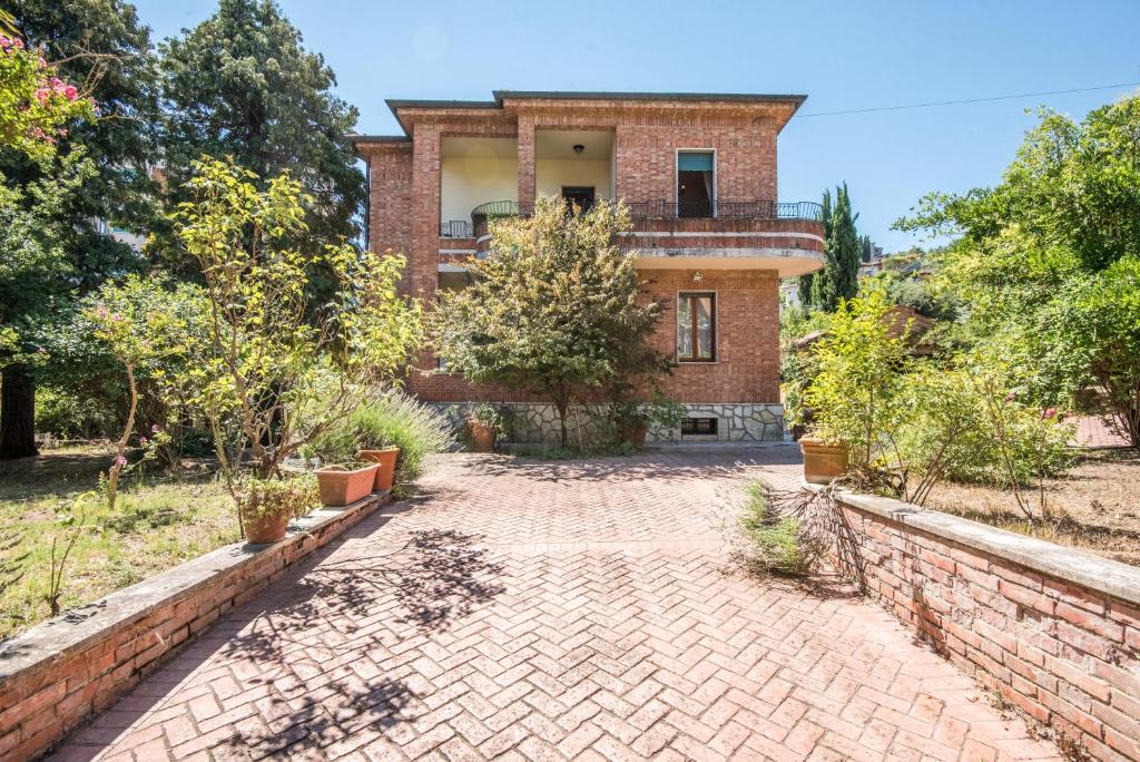 an old brick house with a brick driveway at Villa in Pineta in Sinalunga