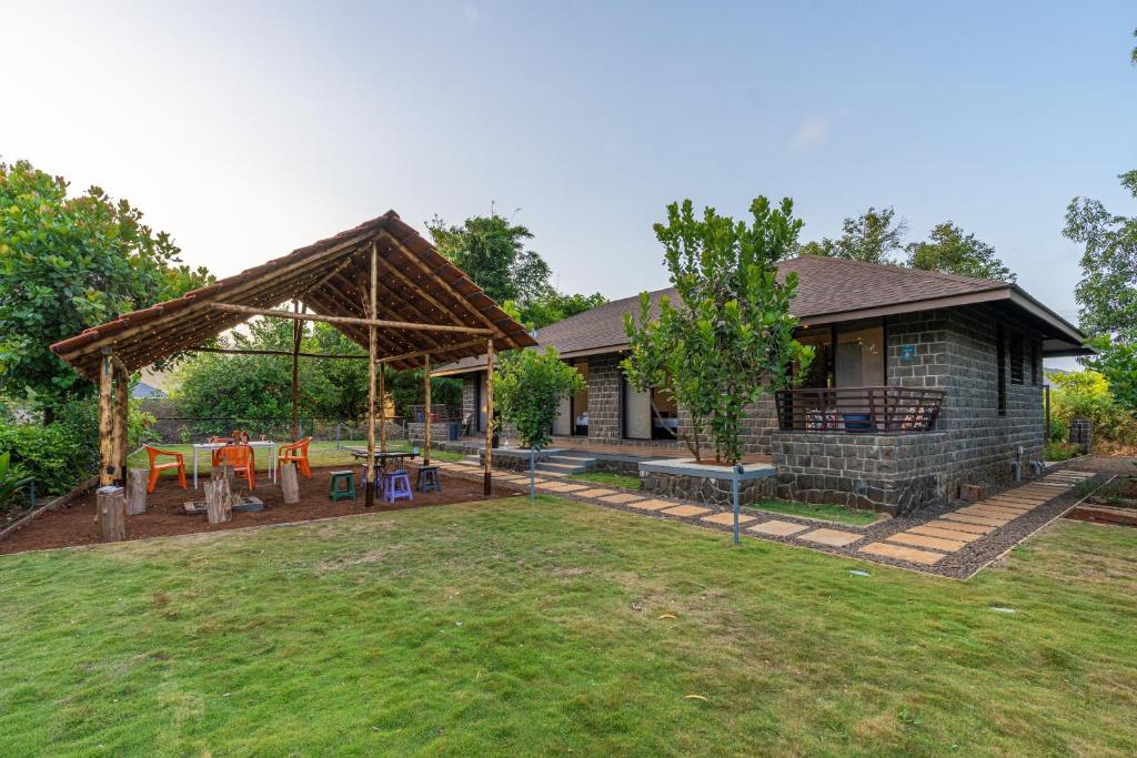 a backyard with a picnic table and a pavilion at Zostel Homes Bhor (Near Pune) in Pune