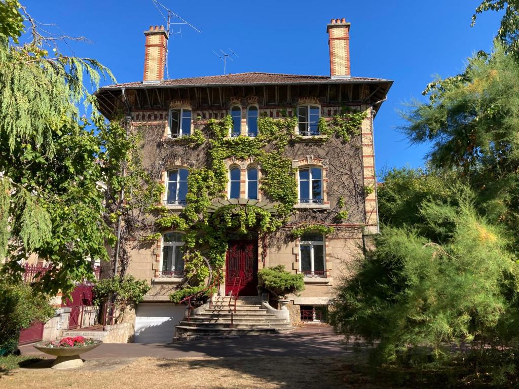 an old stone house with a red door at Appartement Villa Medreville in Nancy