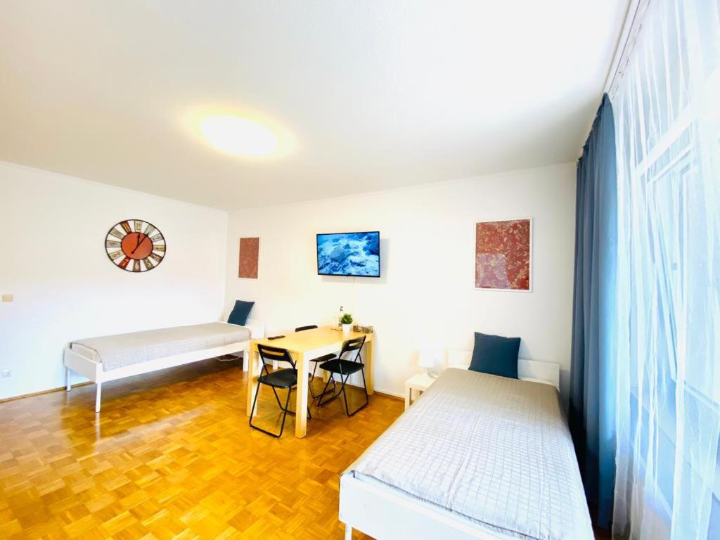 a room with two beds and a table with a tableablish at HannoverMesseApartment 2 bedroom in Hannover