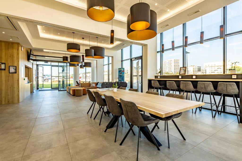 a dining room with a long table and chairs at Evancy La Marina Boulogne-sur-Mer in Boulogne-sur-Mer