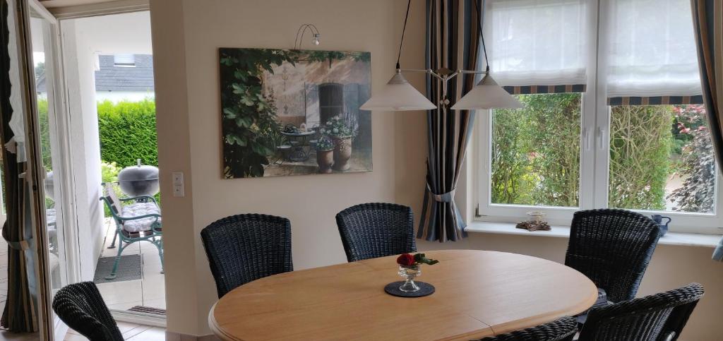 comedor con mesa de madera y sillas en Ferienhaus Schulte - Villa Jupp und Apartment Liesl, en Olsberg