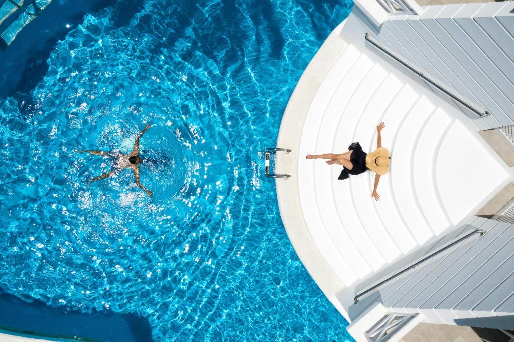 two people are swimming in a swimming pool at Lagos de Fañabé Beach Resort in Adeje