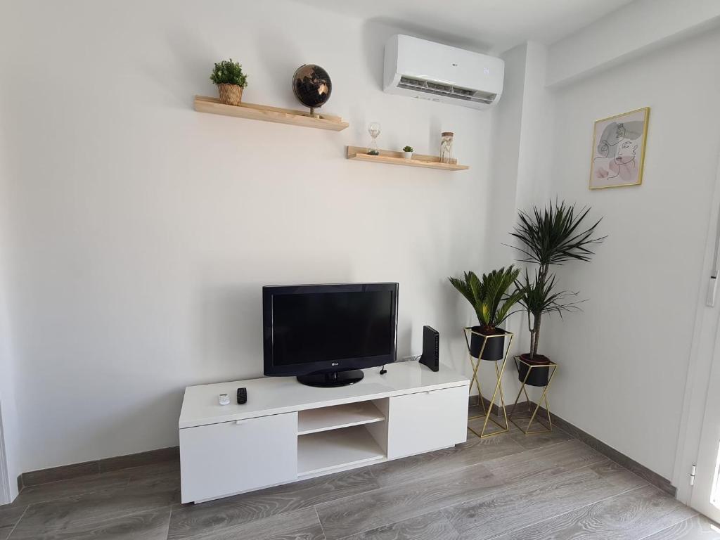 a living room with a tv on a white cabinet at COLON Nerja in Nerja