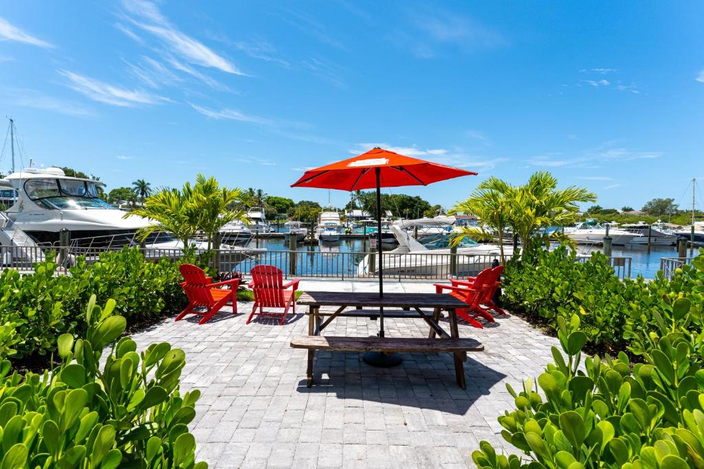 a picnic table with an umbrella next to a marina at Room 127 - Waterfront, Heated Pool, Huge TV, Tiki Bar & Grill in Sarasota