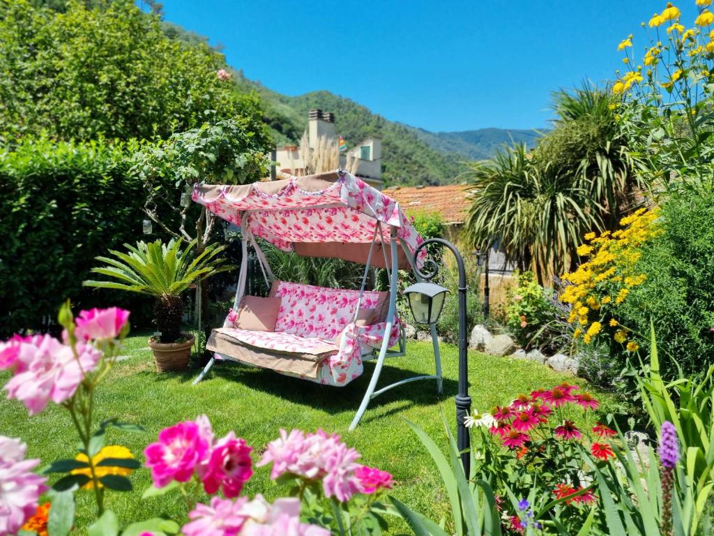 ogród z różowym krzesłem i parasolem w obiekcie Casa Vacanze Family w mieście Albisola Superiore