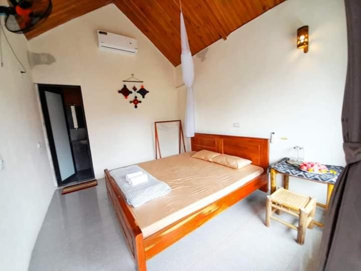 a bedroom with a large bed and a table at Thao Ly Homestay Mai Chau in Hòa Bình