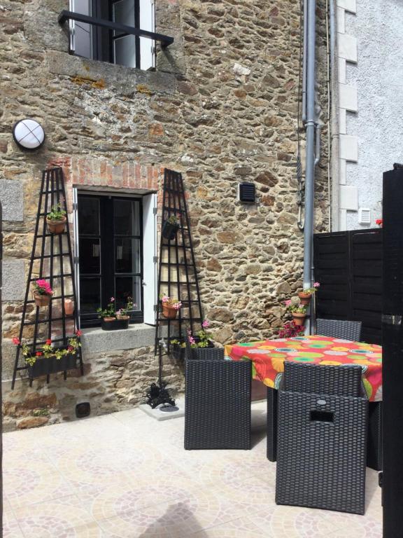 a patio with a table and chairs in front of a building at LA MABONNAIS in Pleurtuit