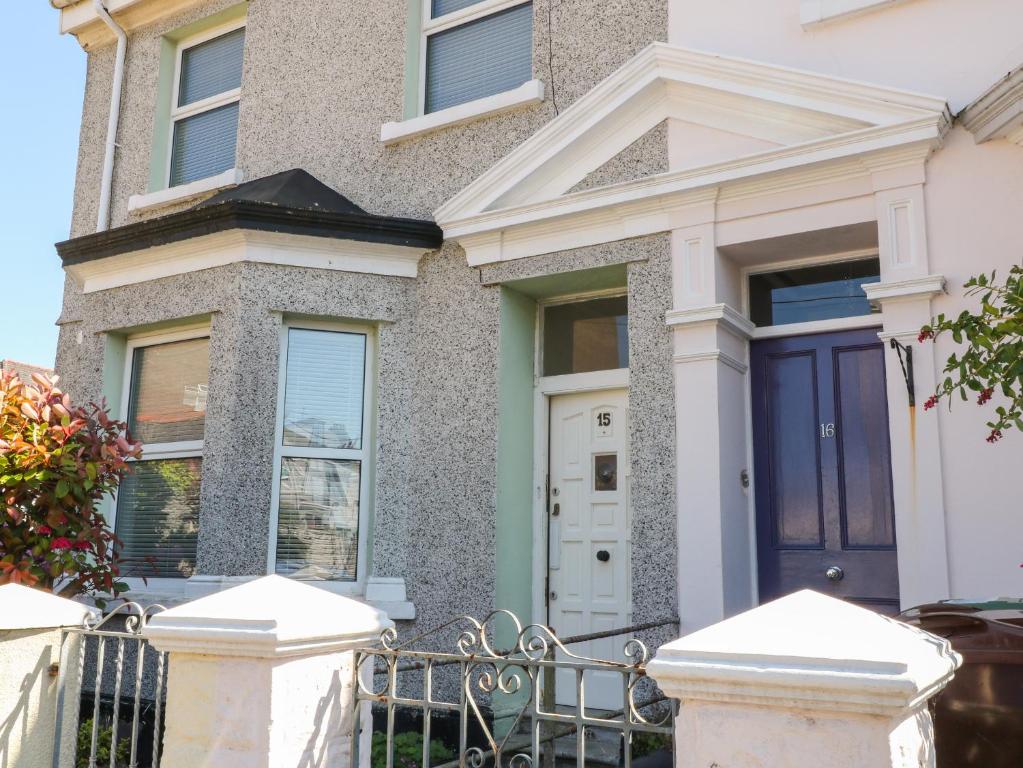 a house with a blue door and a fence at 15 Brunswick Place in Plymouth