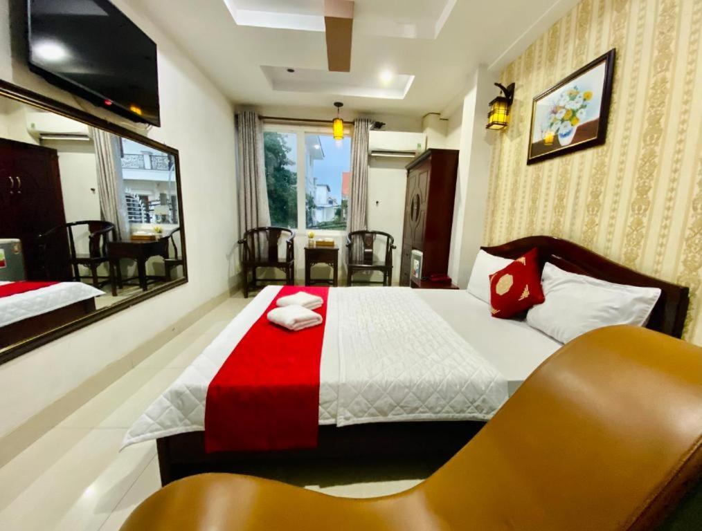 um quarto com uma cama com um cobertor vermelho e branco em Hotel Phương Nam em Ho Chi Minh